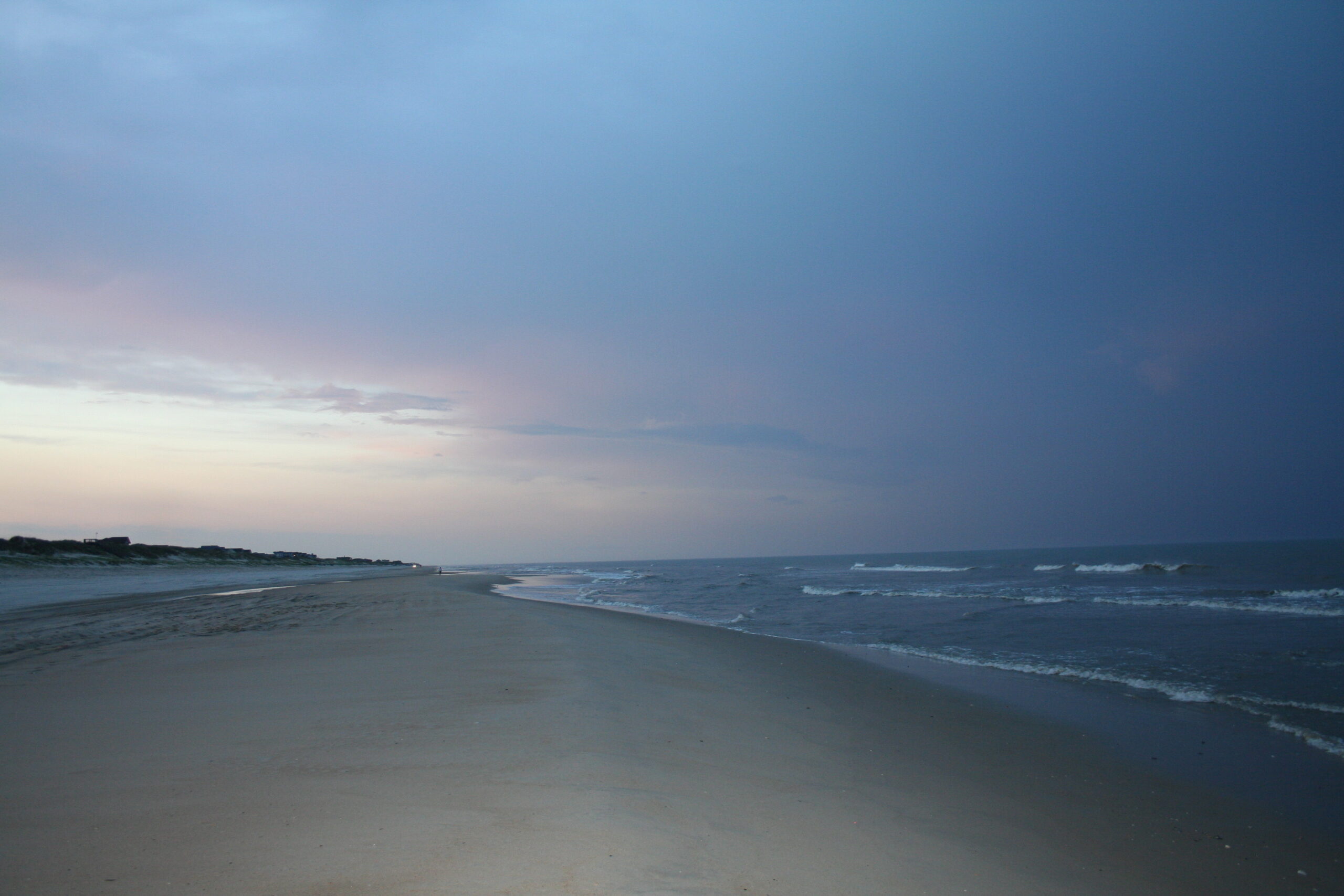 Stark beach with calm ocean against a gray sky